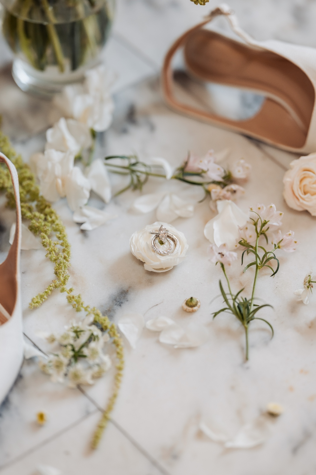 Wedding flat lay with ring, flowers and shoes on marble